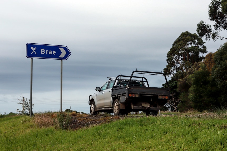 A road sign to Brae with a ute passing on the road