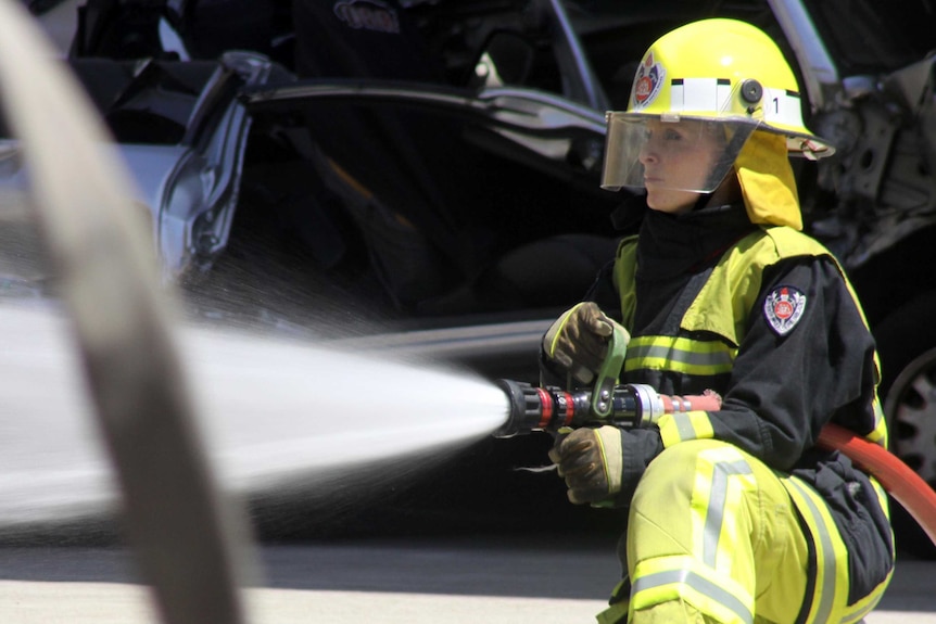 A female NSW firefighter battles a fire.