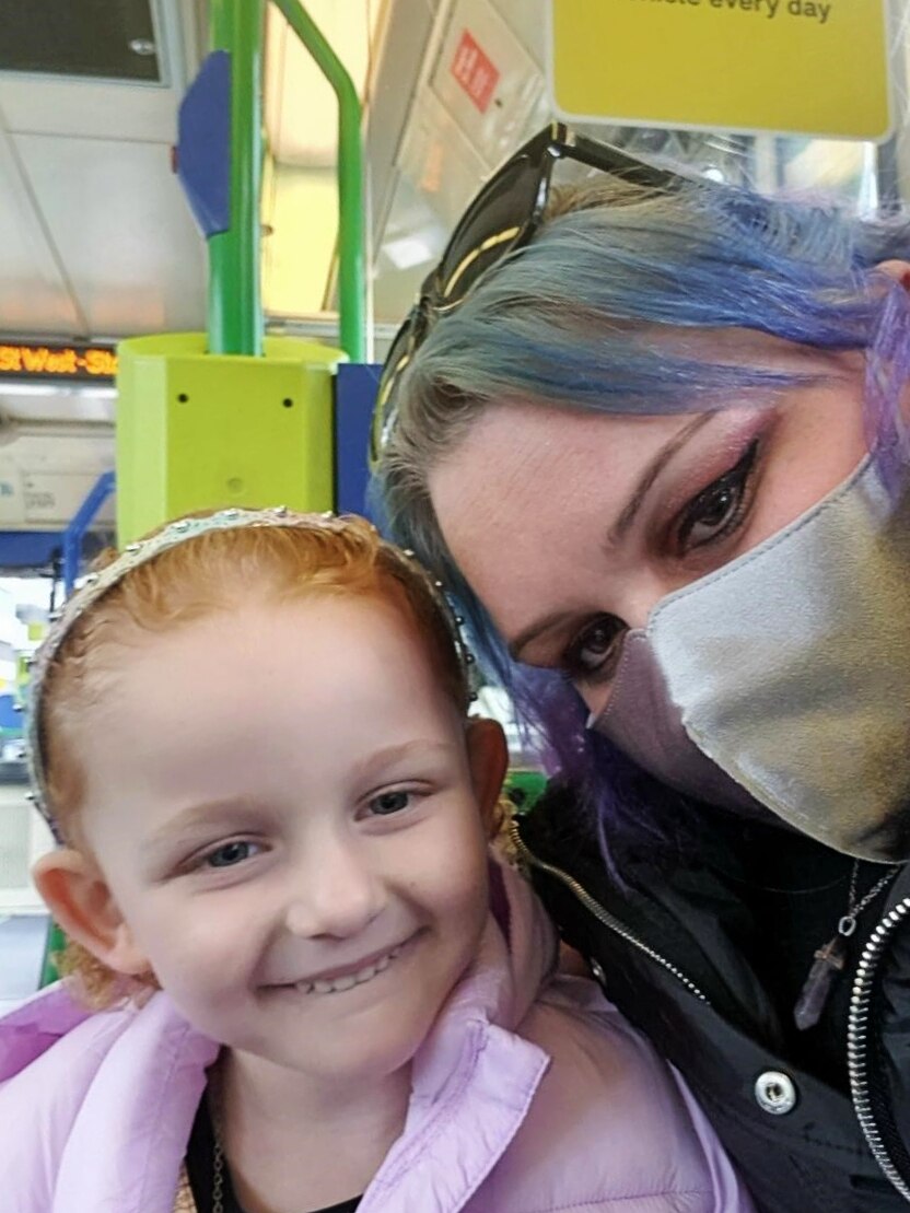 Mother and daughter on a tram in Melbourne, smiling