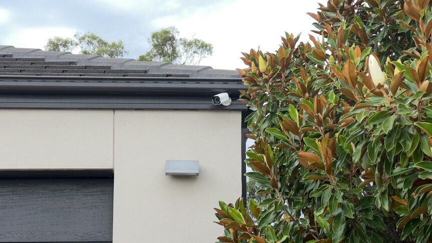 a photo of a security camera on someone's house, looking over the driveway 