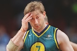 An Australian male wheelchair basketball player touches his forehand with his right hand at the Sydney Paralympics.