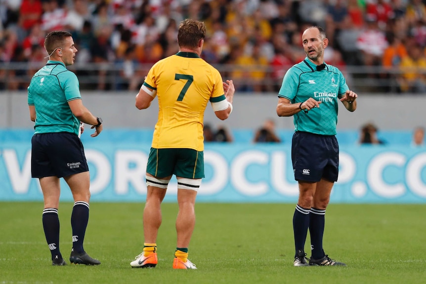 Michael Hooper talks with both match officials during the Wallabies' World Cup match against Wales