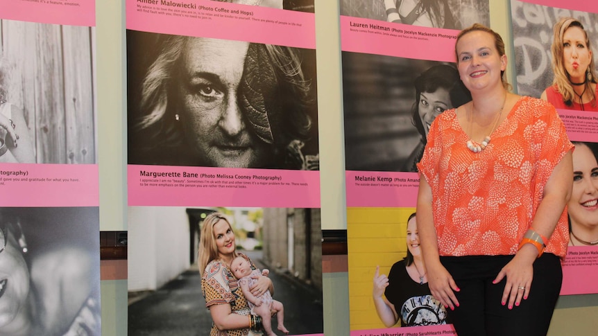 Fallon Drewett in front of her photo exhibition, including a photo of herself and daughter Daisy.