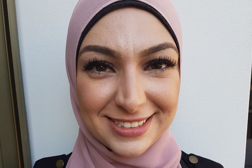 A smiling woman in a pink hijab