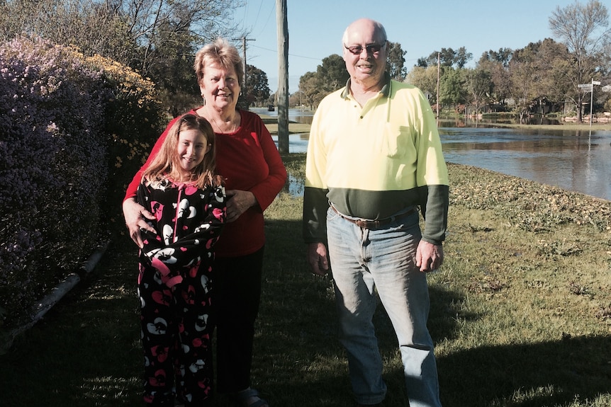 Ian and Margaret Collier with their granddaughter Lara Laws, in their flooded street.