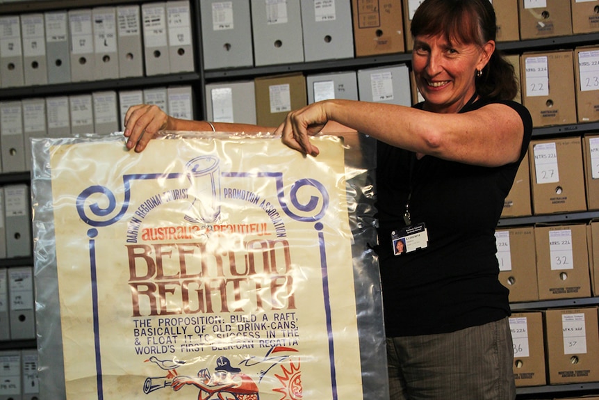 A photo of Archives officer Katherine Hamilton holding up a poster from 1974.