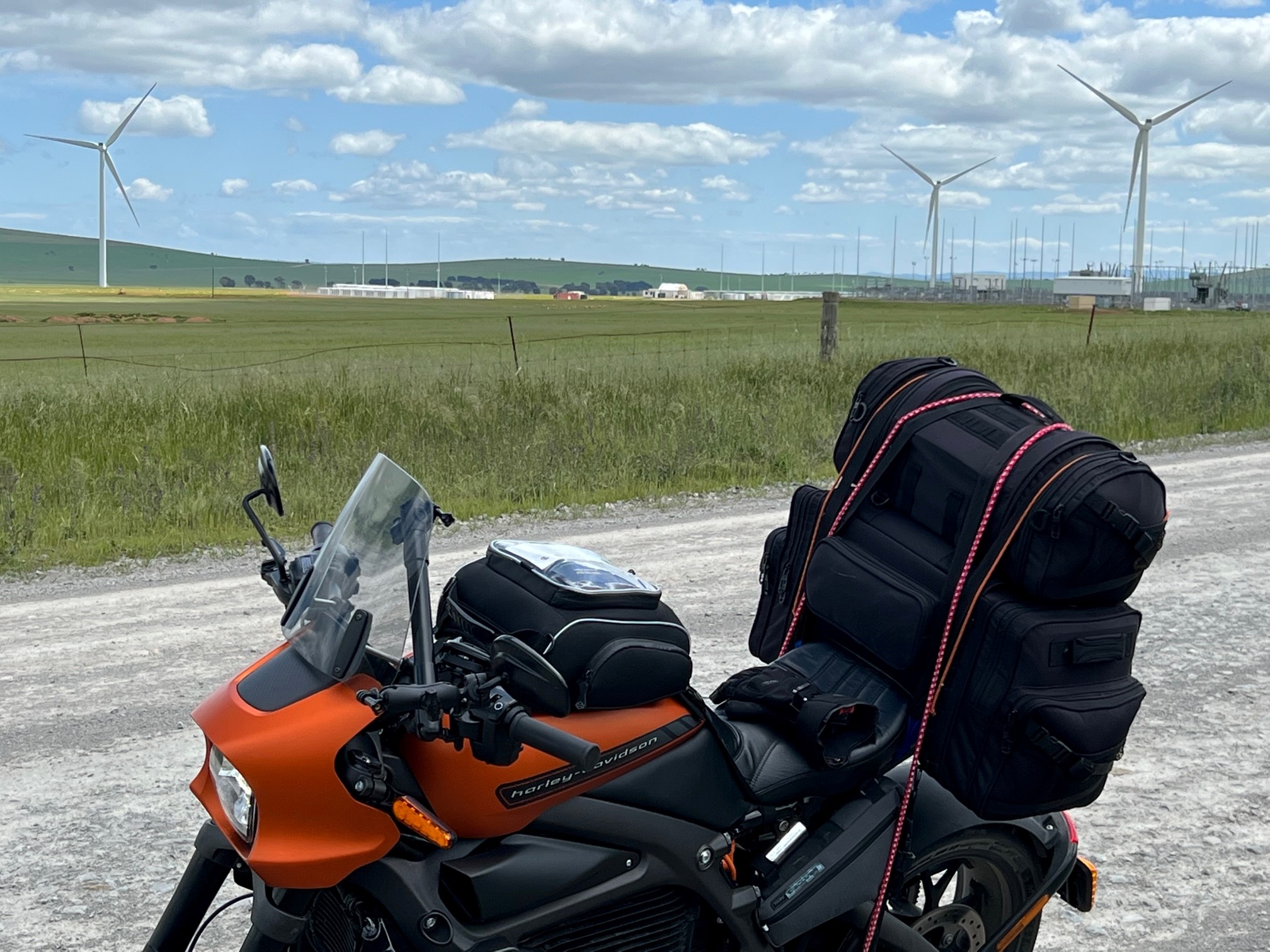 Ed's orange and black Harley parked near a wind farm in rural South Australia 