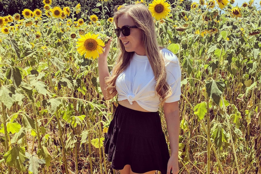 A woman standing in a field of daffodils