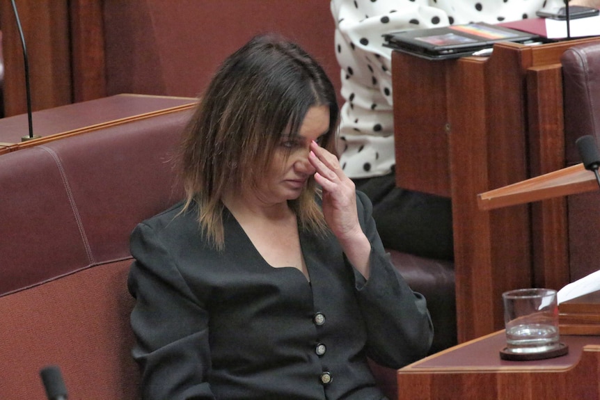 Jacqui Lambie appearing to wipe a tear from her eye while in the Senate