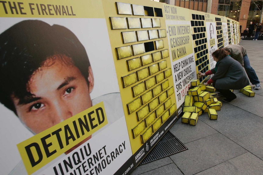 Volunteers place cardboard bricks into a symbolic firewall before a protest in Sydney.