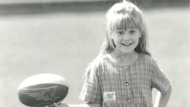 A photo of Clare Milne, Sylvia's daughter as a young child holding a football.