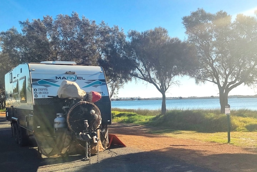 An RV parked at a lake.