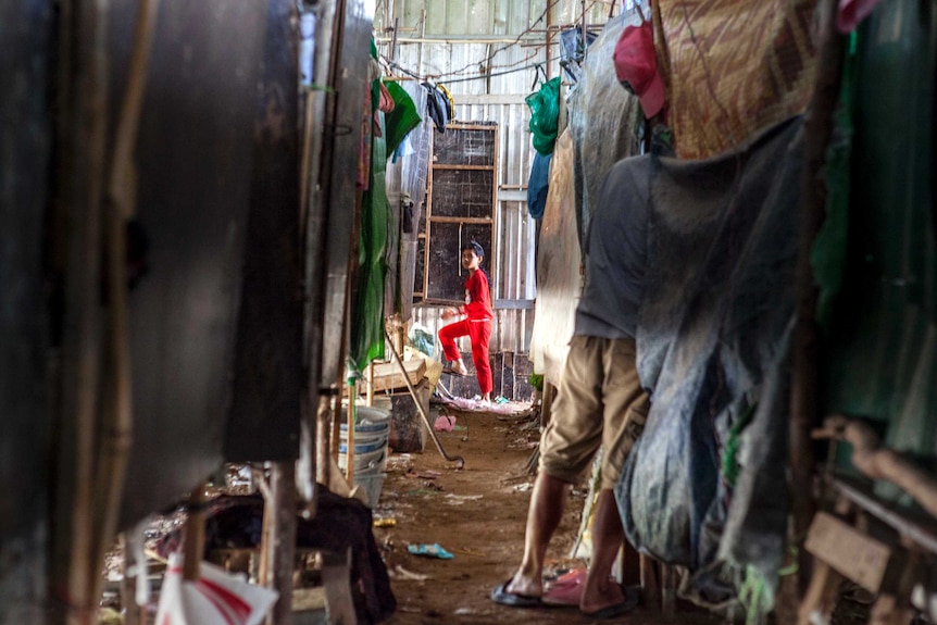 Inside the single, narrow alley in a shed built by the construction company to house its workers.