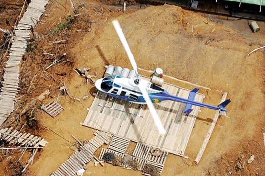 A Bell 206 helicopter owned by the transport company Hevilift sits of the ground.