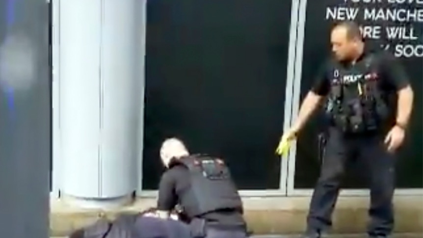 Police arrest a man outside the Arndale Centre in Manchester, England.