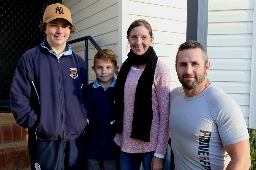 Brad Fewson outside his house with his wife Laura and two sons.