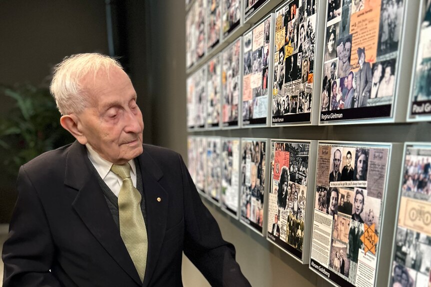 A man with a walker looking at a Holocaust exhibit