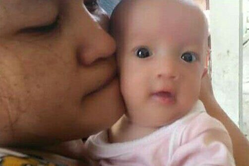 Henny Silalahi and baby Tiara Deborah Simanjorang. Henny is kissing Deborah on the cheek.