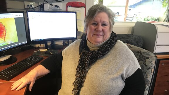 A woman sits at her computer