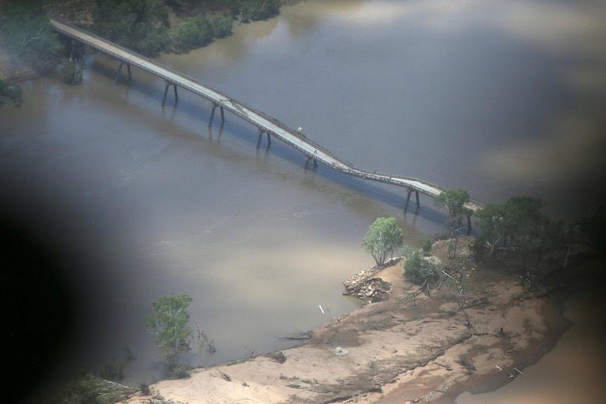 An aerial shot of a bridge with a sagging section in the middle. 