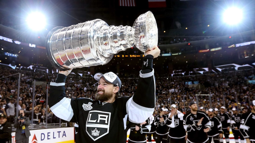 LA Kings player Justin Williams holds the Stanley Cup after the Kings defeated the NY Rangers.