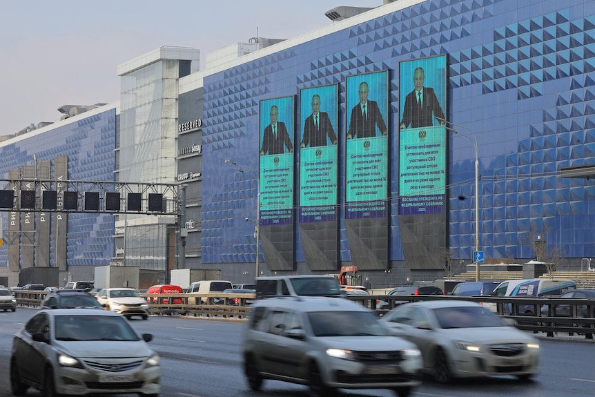 Russian President Vladimir Putin is seen on screens installed on a shopping mall.