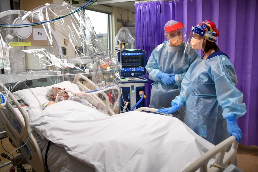 Dr Forbes McGain discusses an ICU patient with a nurse
