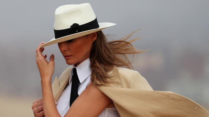 Melania Trump holds her hat down over her head while on a tour of the pyramids in Cairo, Egypt