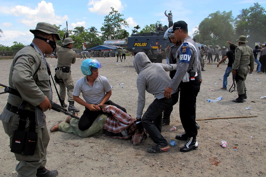 Indonesian police arresting a West Papuan man.