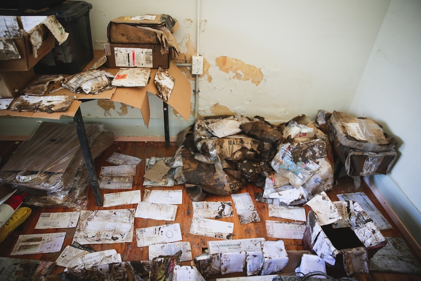 severely water damaged mail bags sit on the floor.