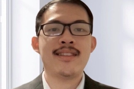 A profile picture of Quang Nguyen, wearing black-rimmed glasses in front of a white background