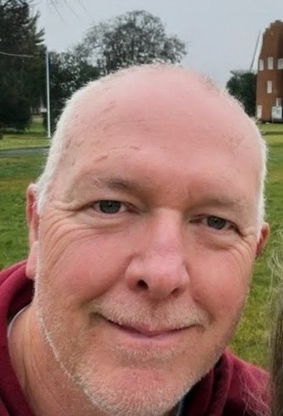 close up of man with grass in the background