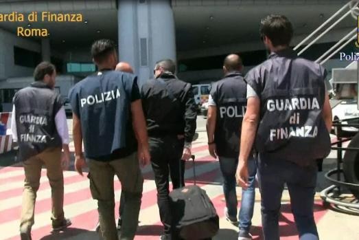 Four italian police officers arrest a man at Rome International Airport