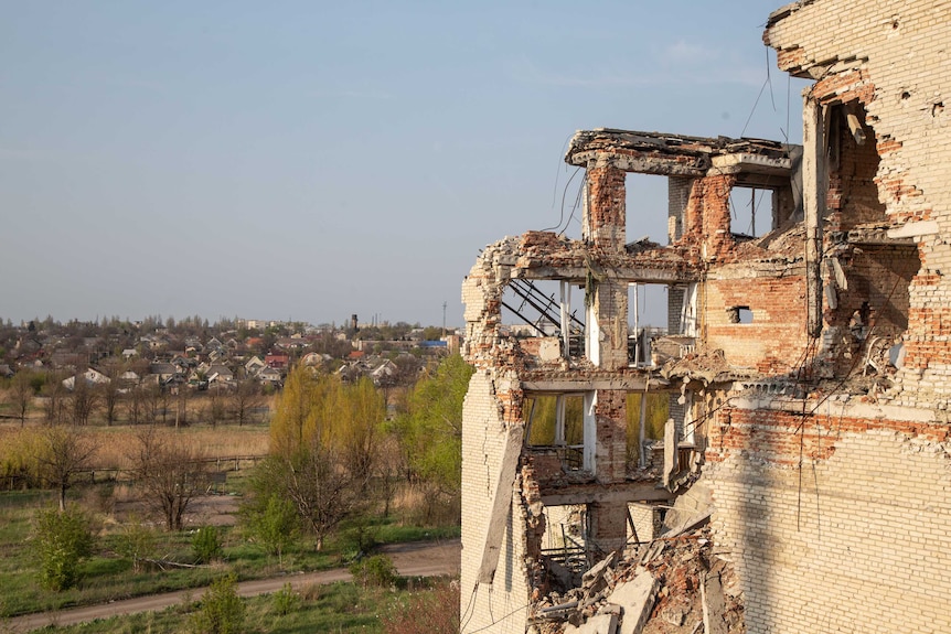 A crumbling building overlooks a town.