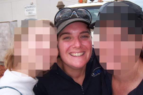 Mara Harvey smiles posing for a photo wearing a baseball cap between two other women, whose faces are pixelated.