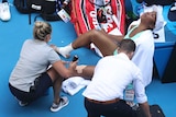 Venus Williams receives treatment for injuries from two trainers during the Australian Open.