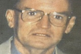 Grainy image of an older man in spectacles