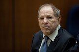 Harvey Weinstein dressed in a suit, sitting in a court room 