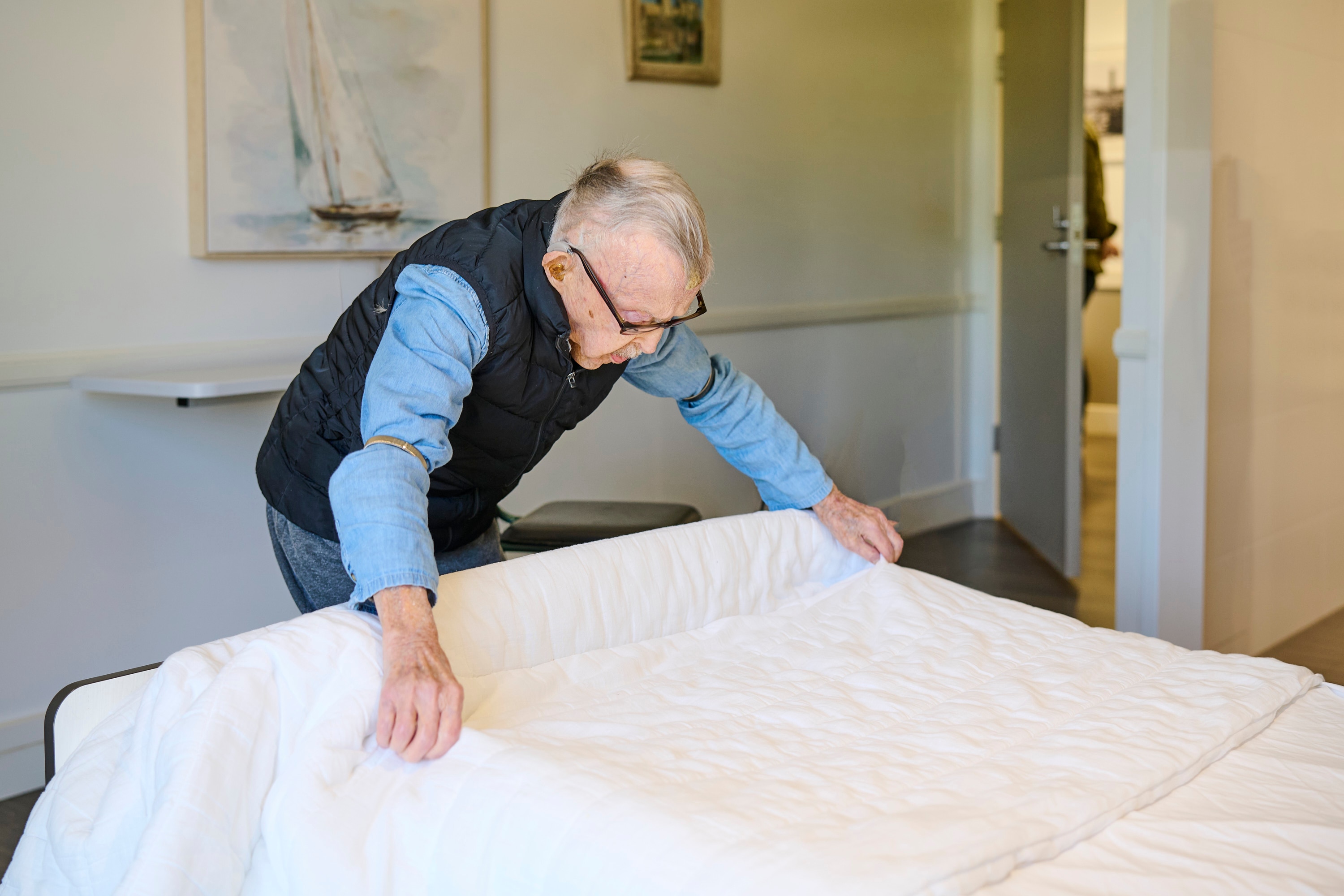 A man aged 113 makes his own bed.