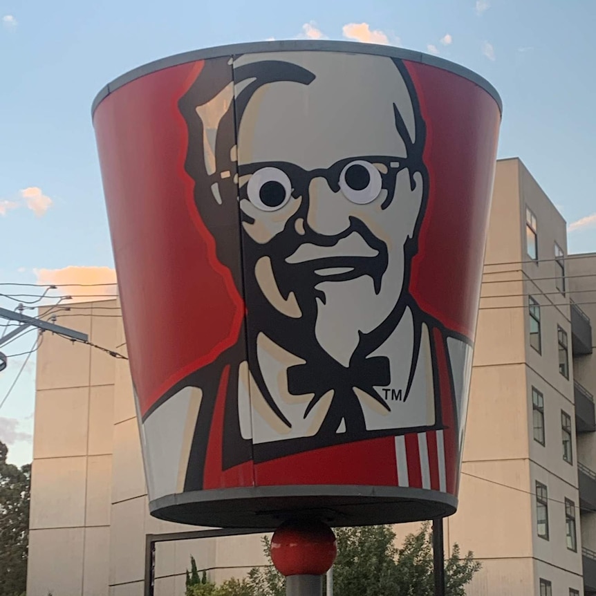 Googly eyes on a large image of the KFC Colonel Sanders