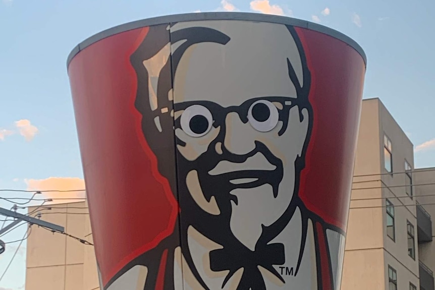 Googly eyes on a large image of the KFC Colonel Sanders