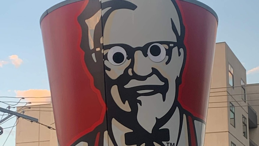 Googly eyes on a large image of the KFC Colonel Sanders