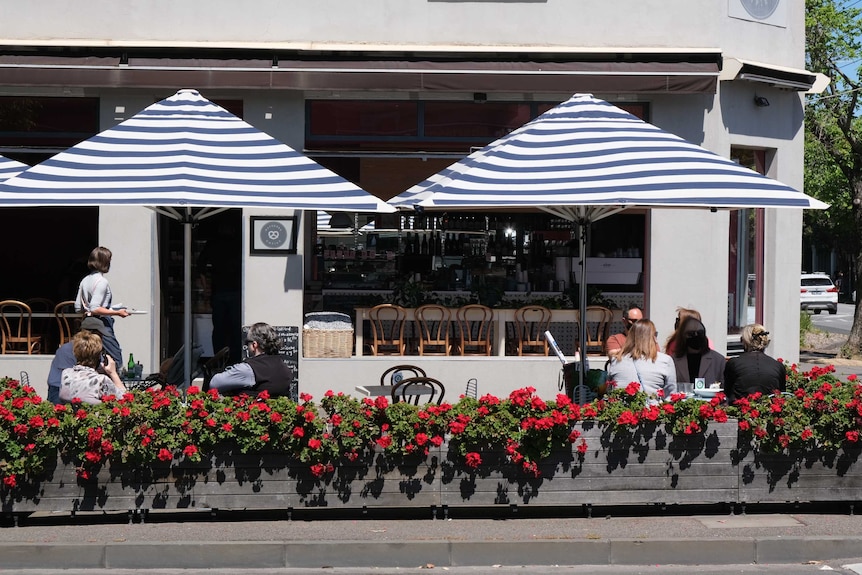 Stripped umbrellas and red flowers in boxes on a sunny day.