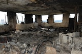 A view inside one of the flats shows all the windows smashed out and everything burnt to ash.