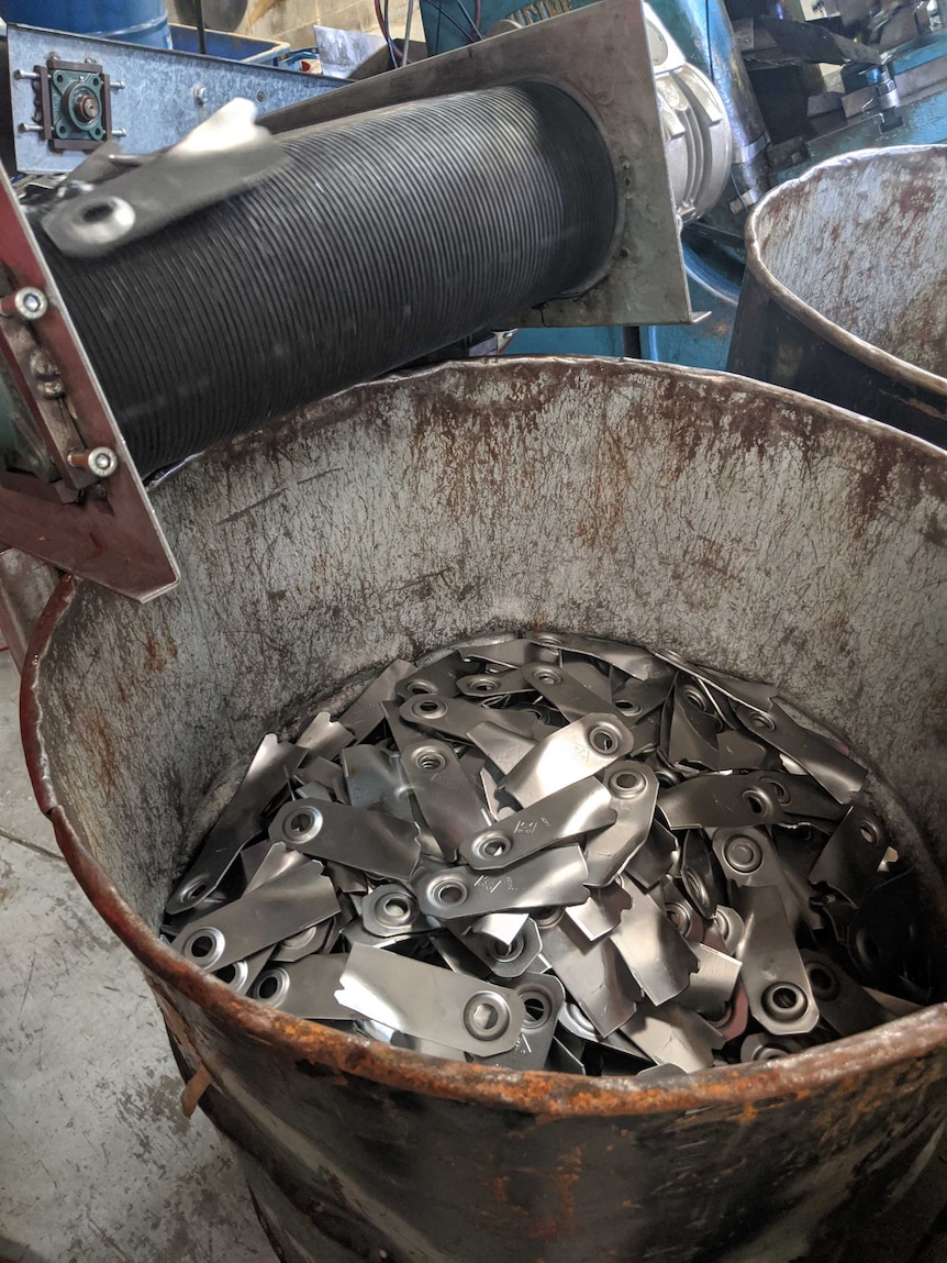 Hundreds of lawn mower blades can be shining from the bottom of a big industrial metal bucket.