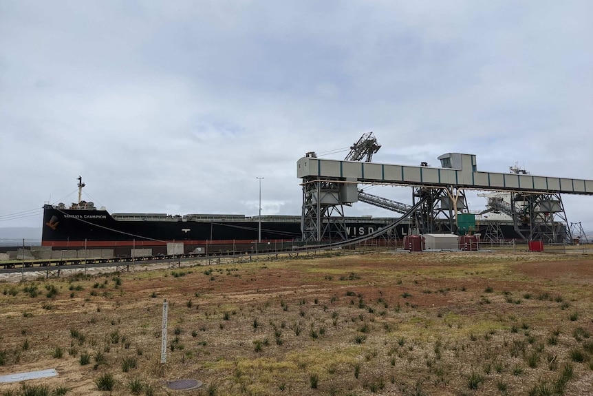 A tanker sits berthed in a harbour