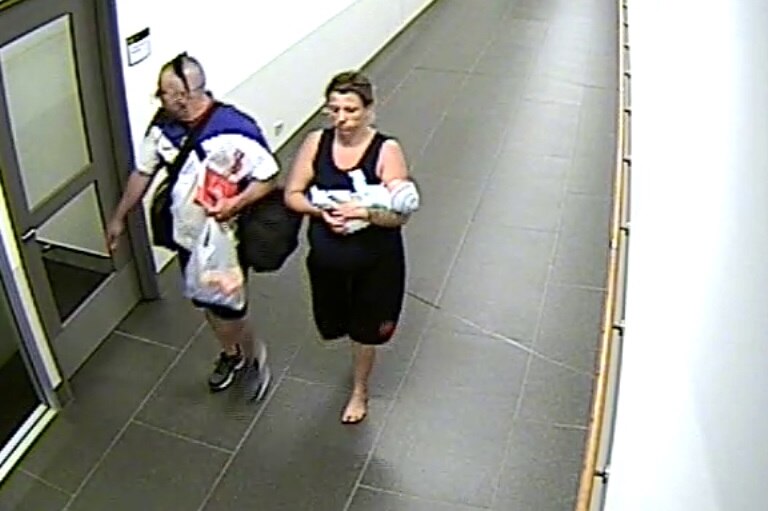 Man, woman, and baby leaving Gold Coast University Hospital