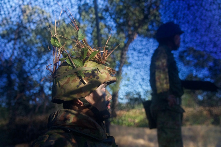 A man wearing Australian flora on his military helmet.