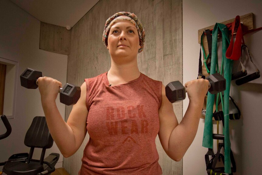 a woman in a headscarf lifts weights