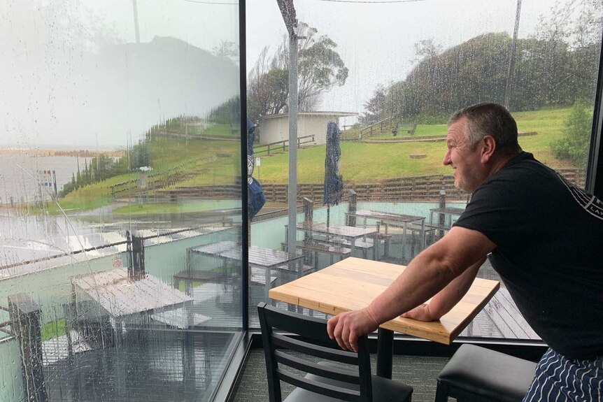 A pub owner looking out over the water from his business